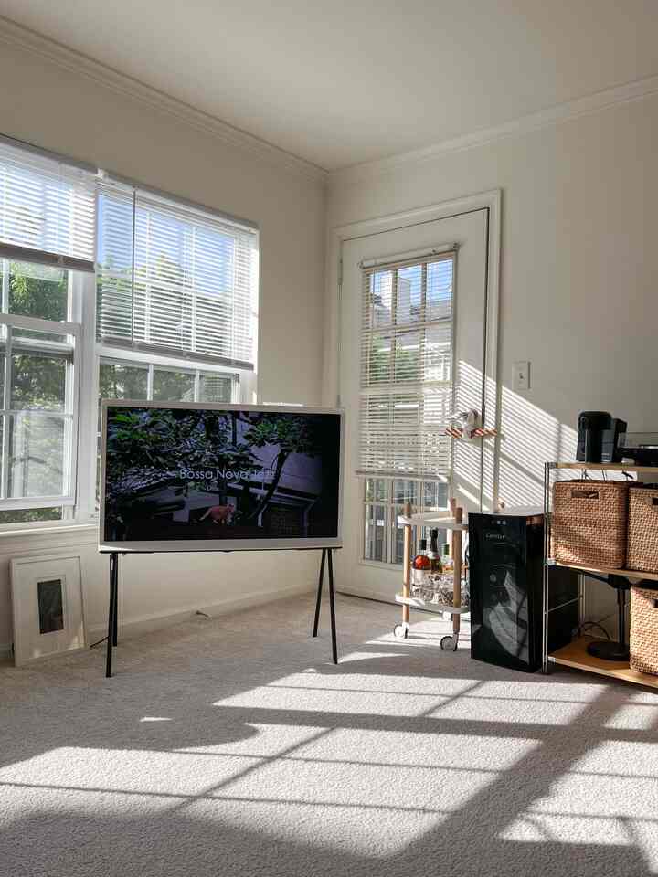 White-toned living room featuring a TV stand and home bar with a bright and minimalist atmosphere