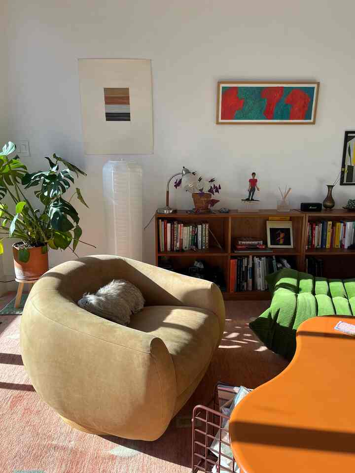 Beige and green toned living room featuring a large armchair and plant creating a natural atmosphere