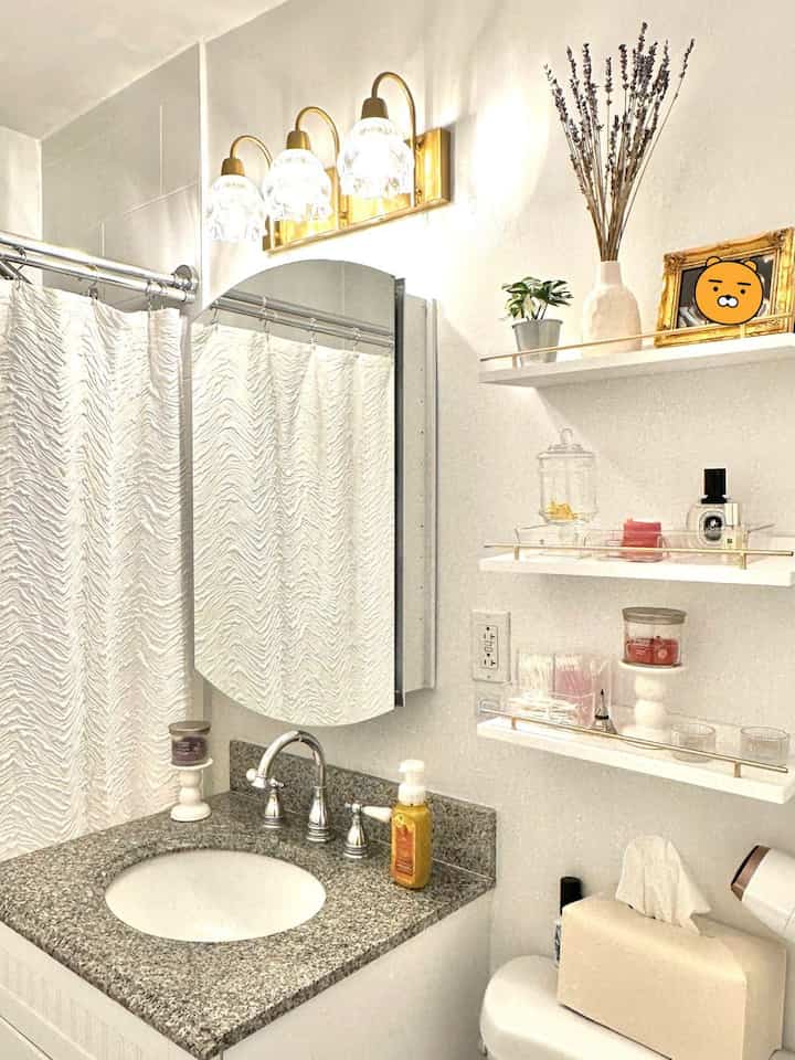 To glow up a bathroom, I switched the lights to a warm floral lamp that isn’t too bright, and installed a floating shelf on the right for easy reach to place some essentials and decor. 

10 out of 10 would recommend a floating shelf if you have a small bathroom like mine as it provides so much space for items that would otherwise be placed on the bathroom sink.

The floating shelf also provides a more elevated look overall, and the small gold shaded guard rails at the front are also a functional and nice touch of elegance I adore.

If you like french modern interior like I do, try placing ornate frames, plants in tin or ceramic vases, and a small eiffel tower on the shelf. ✨

#bathroom #romantic #frenchmodern 