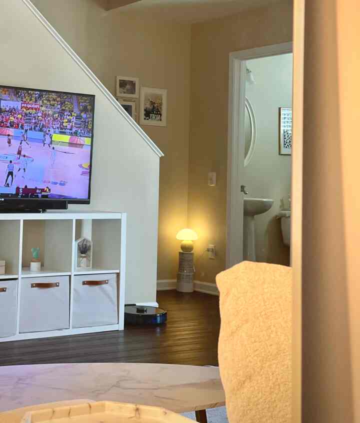 White and brown toned living room featuring TV stand and table lamp with cozy atmosphere