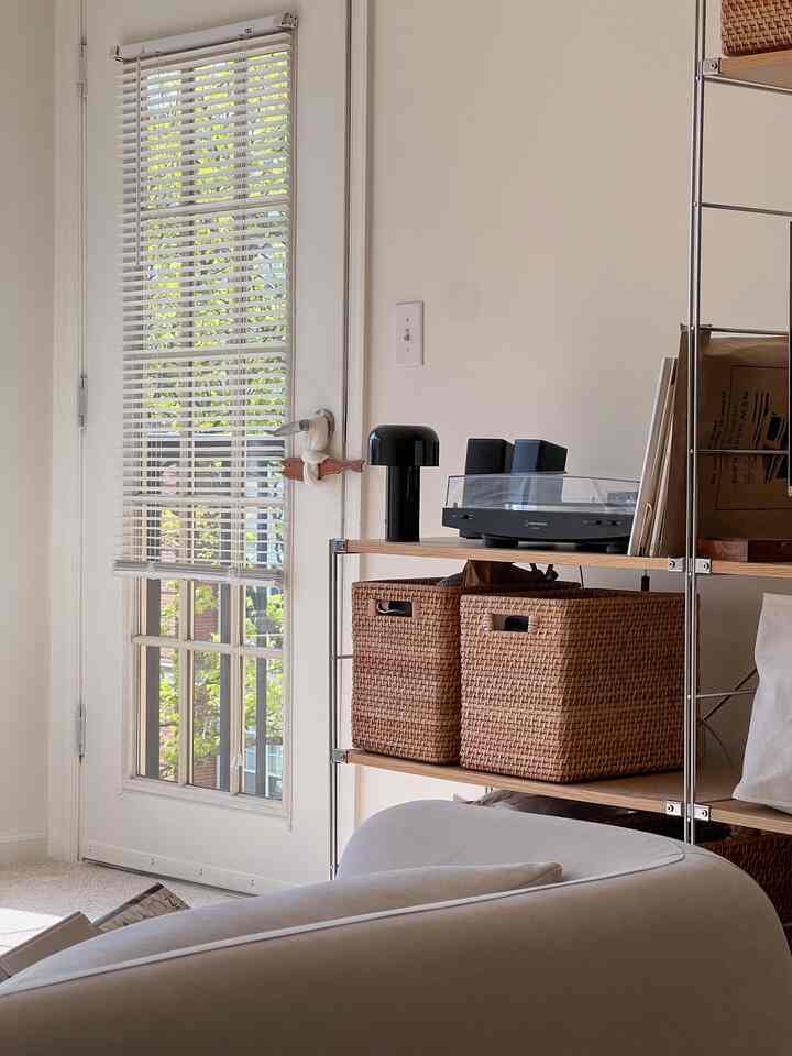 White and natural color living room featuring an Audio-Technica turntable and woven storage baskets in a clean setting