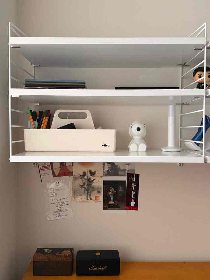 White-toned home office shelf featuring Vitra Toolbox and Snoopy figurine in a tidy setting