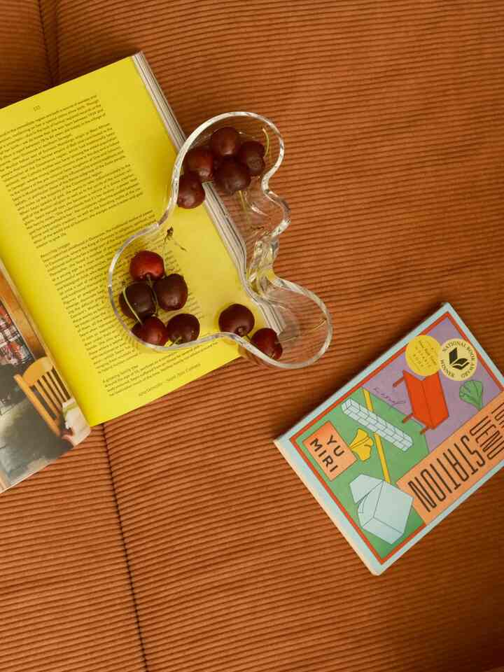 Warm brown-toned living space featuring an Alvar Aalto glass bowl with cherries, styled for a cozy atmosphere