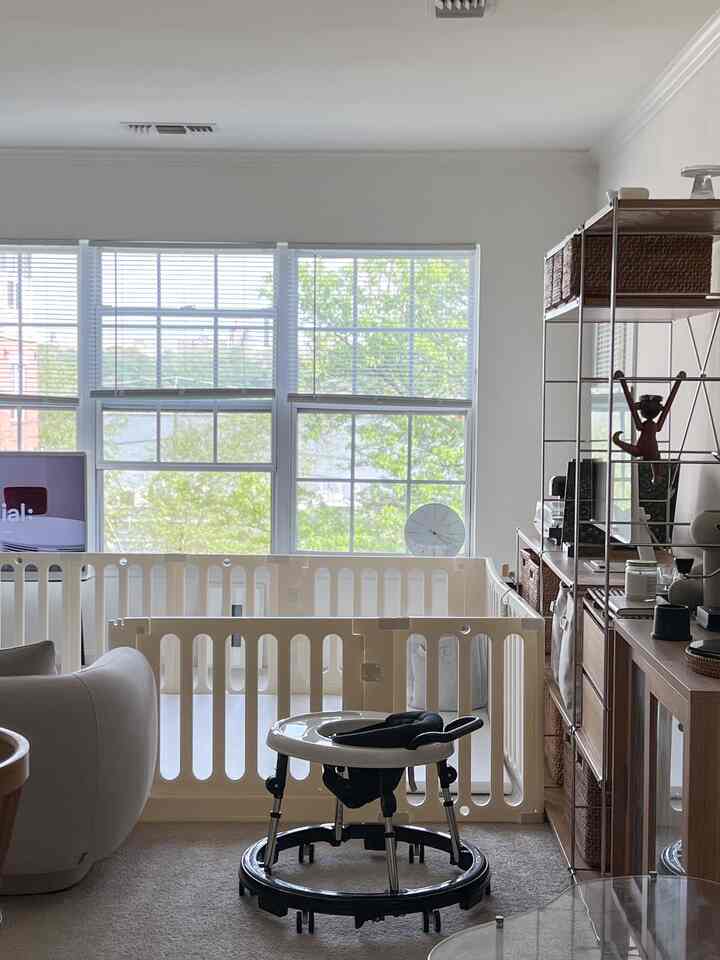 Beige and white toned living room featuring baby safety gates and walker creating a cozy space