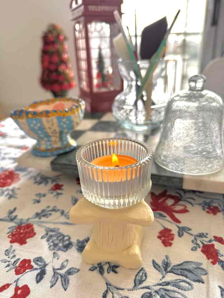 Red and blue floral tablecloth with a mini candle holder and burning candle in a French modern styled dining setting
