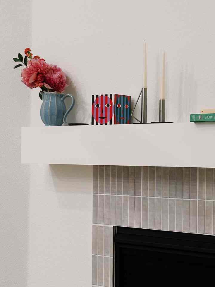 White and natural color corner storage wall shelf featuring a vase with flowers and candles in a cozy setting