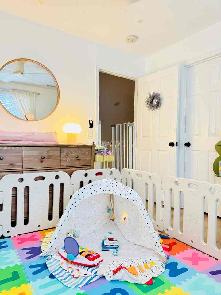 White-toned kids' room featuring safety gates and baby toys with bright, cozy atmosphere