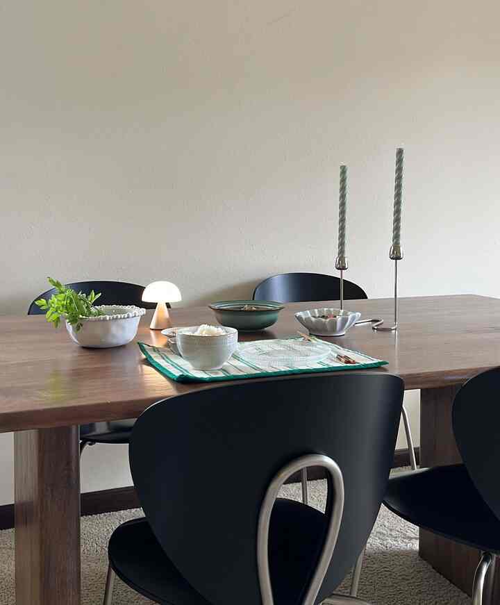 Simple modern dining room with brown wood tone dining table and black dining chairs