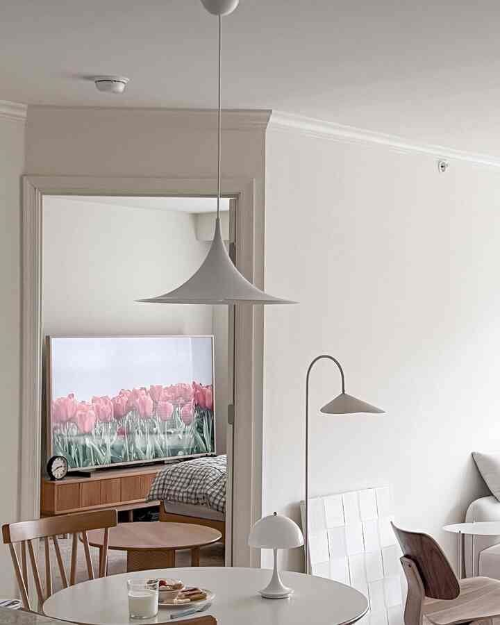 White and wood tone living and dining room featuring simple natural furniture with a calm atmosphere