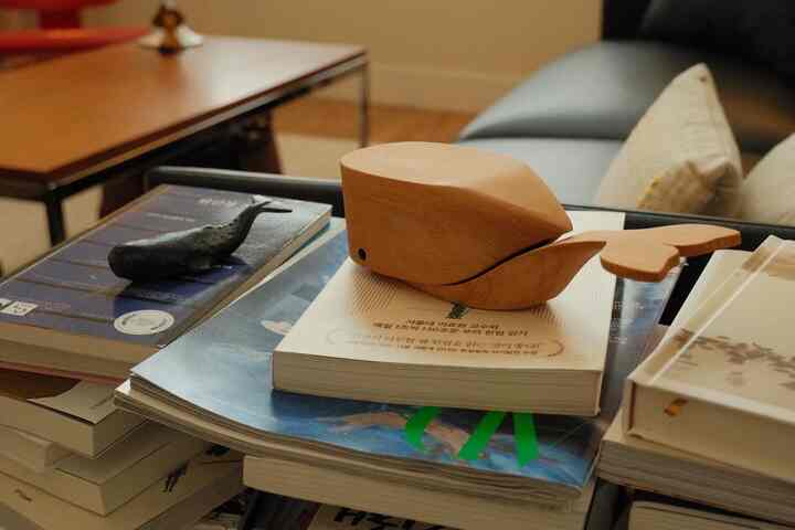 Warm wood-toned modern home office space featuring a coffee table with treasured decorative objets in a cozy living room