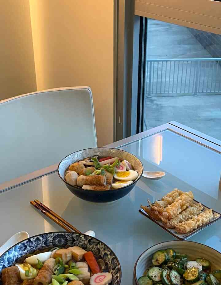 Cozy dining room with white walls and chair, featuring glass dining table with Japanese ceramic bowls and chopsticks