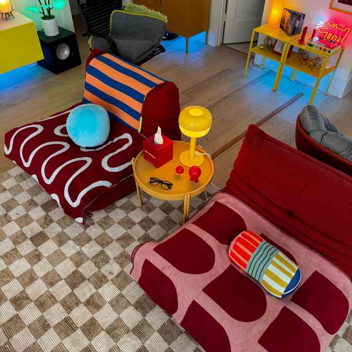 Colorful living room featuring Togo-style bean bags and yellow side tables with a cozy, playful atmosphere