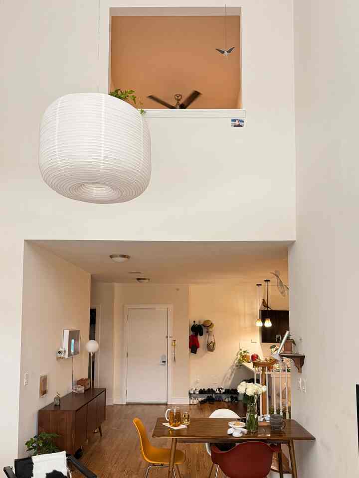 White and wood tone natural modern dining room for two-person household with key furniture and lighting