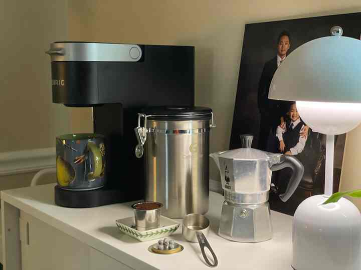 White shoe cabinet topped with a coffee machine and coffee tools in a cozy home cafe setup