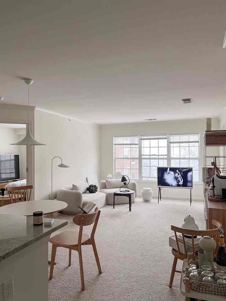 Beige-toned living room featuring sofas, dining chairs, and TV stand with a modern and natural atmosphere