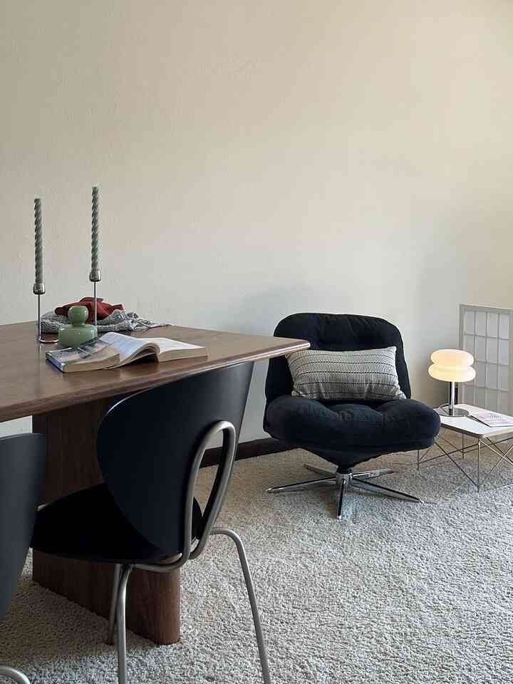 Natural tone living and dining room featuring a brown dining table and black chairs with a simple, modern atmosphere