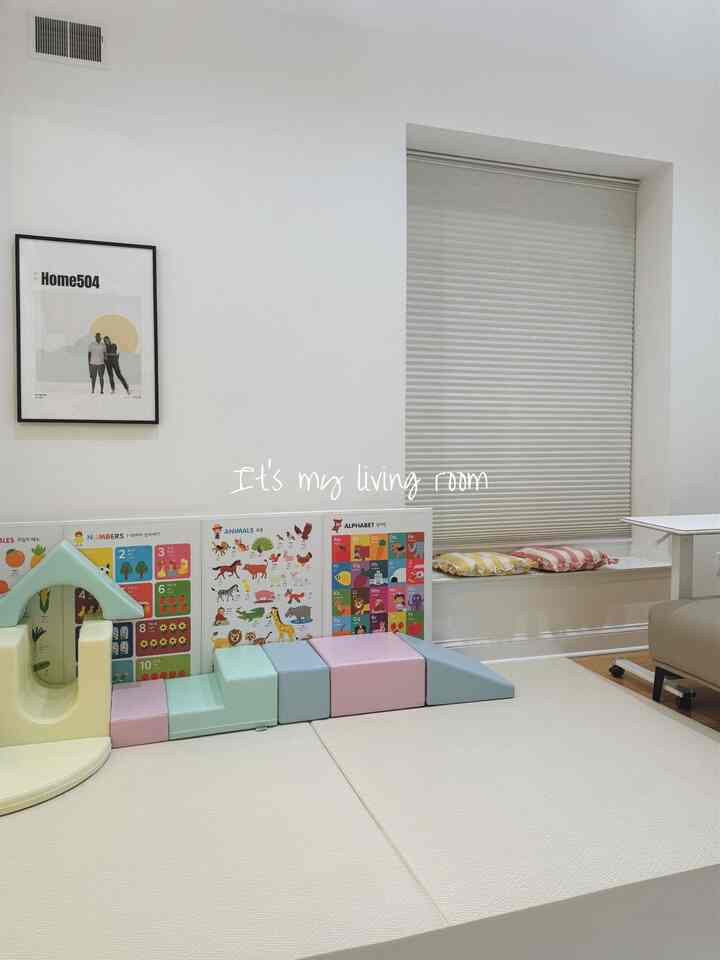 Pastel and white kids' room featuring multifunctional foam play set and educational picture frame with a cozy atmosphere
