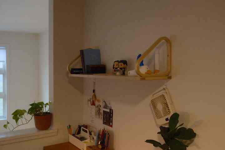 Cozy home office space in warm brown and white tones featuring a wall shelf and plants for a calming work environment