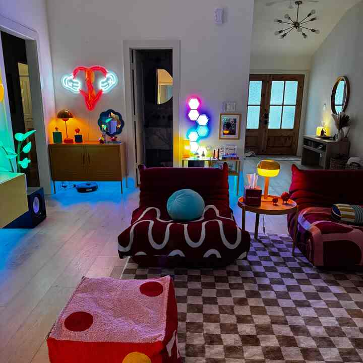 Living room with red bean bags and yellow lamps, colorful neon lights create a vibrant atmosphere