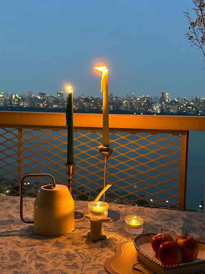 White and ivory toned balcony featuring candles and watering can with warm, romantic atmosphere
