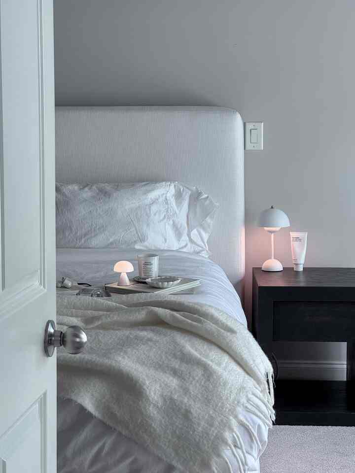 White and gray toned bedroom featuring a white bed and blanket with a modern and minimal atmosphere
