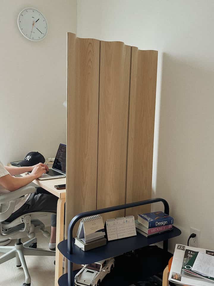 Natural brown-toned home office featuring a wooden folding screen, desk, and office chair in a tidy workspace