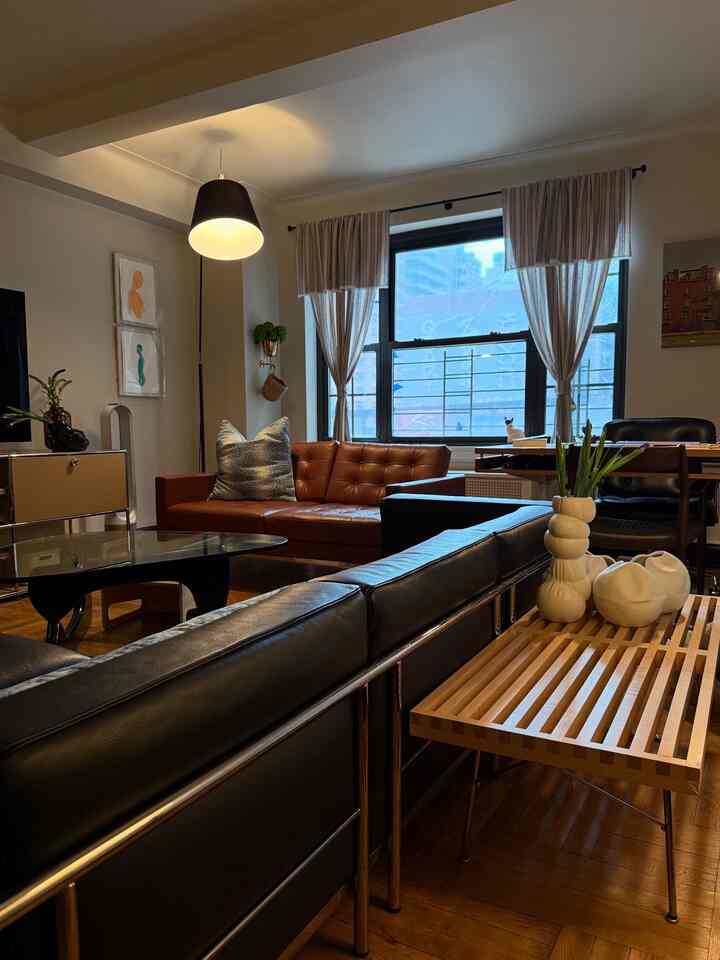 Black and brown colored living room featuring modern sofas and a coffee table with cozy natural lighting
