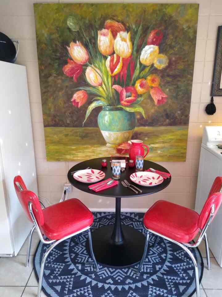 Making the most of our tiny kitchen! This little table is perfect for two. Love the pop of red from the chairs. #smallspacedesign #kitchenideas #vintage