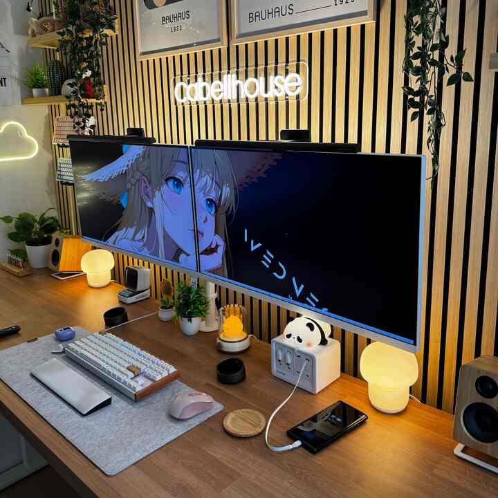 Wood tone wall panels and desk in a home office space featuring dual monitors and keyboard, creating a neat remote work setup