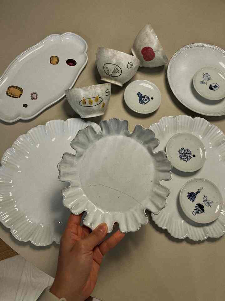 White ceramic plates and bowls arranged on a surface, evoking a vintage French Country kitchenware style
