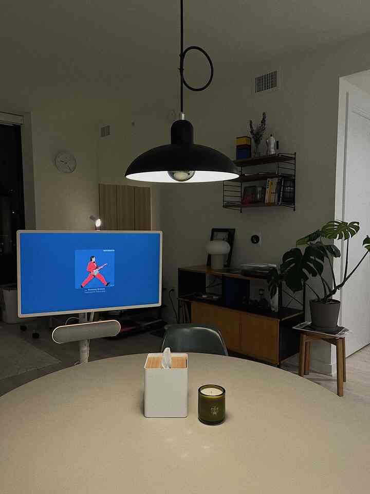 Natural and modern toned home office space featuring a round dining table, desk, and pendant light creating a cozy work environment