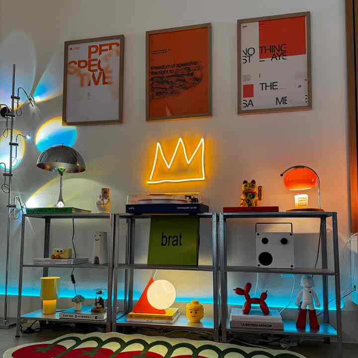 Living room with white walls featuring metal shelves and various objects, creating an Instagrammable cozy atmosphere