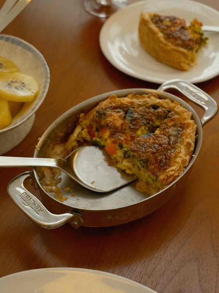 Brown wood-tone dining table featuring stainless steel oval ovenware and cutlery representing a kitchen dining setting