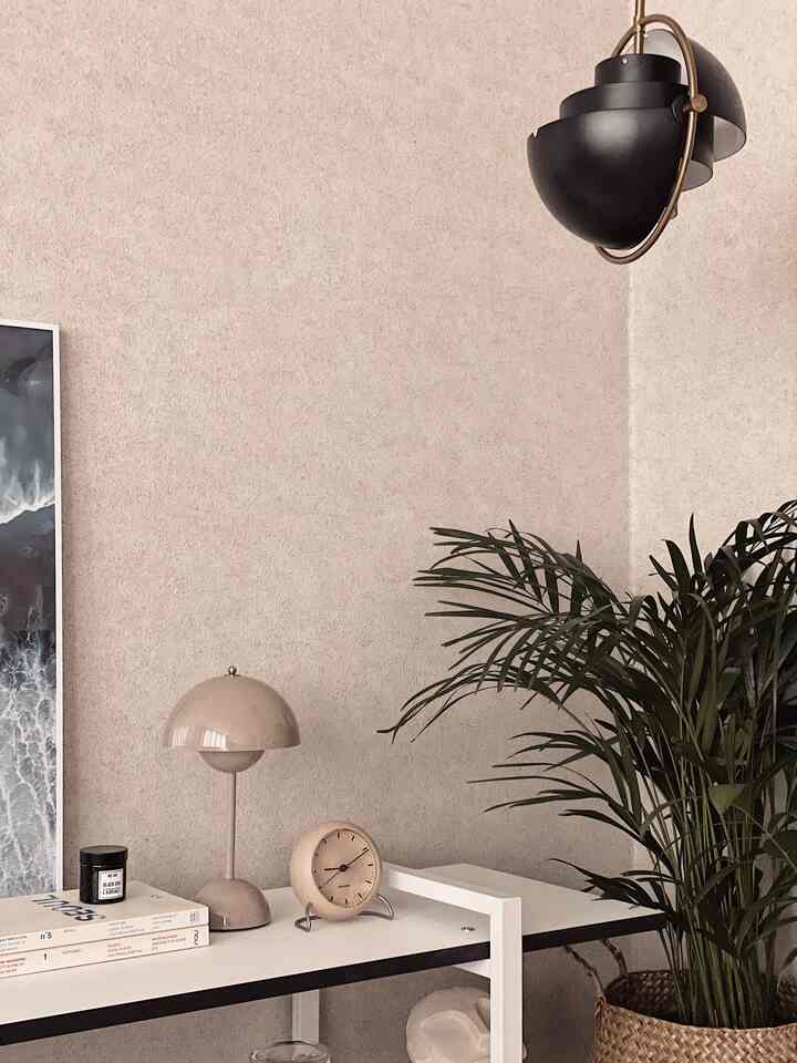 Natural colored and white bedroom corner featuring a nightstand with beige clock and lamp creating a cozy atmosphere