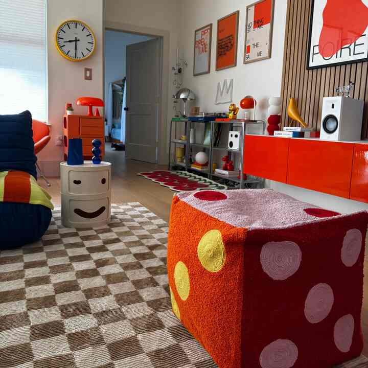 Orange and blue toned single household living room featuring unique sofa and colorful decor elements with a modern cozy atmosphere