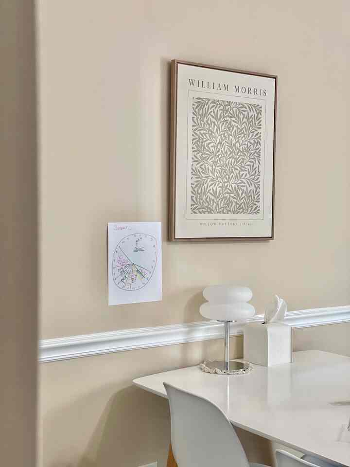 Beige wall and white dining area featuring picture frame with a clean and warm atmosphere
