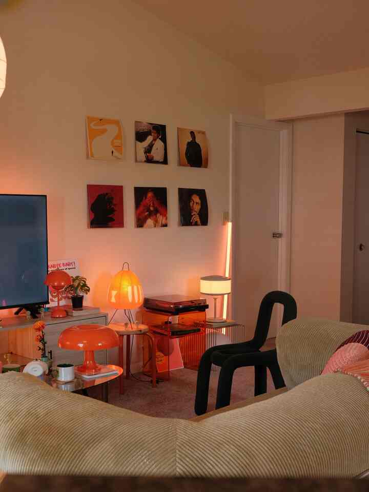 Beige and orange toned living room featuring a sofa, side tables, and table lamps creating a cozy atmosphere