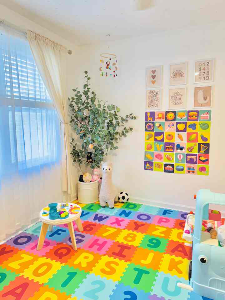 White and ivory toned kids' room featuring colorful alphabet and number play mat with a baby activity table, creating a cozy atmosphere