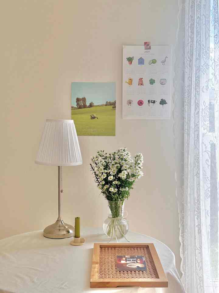 White and beige toned living room featuring table lamp and vase with flowers creating a cozy warm atmosphere