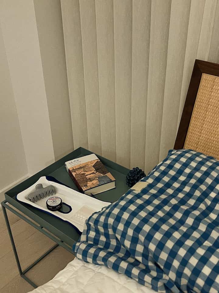 Natural beige and blue checkered bedroom with wooden headboard and tray, creating a cozy atmosphere