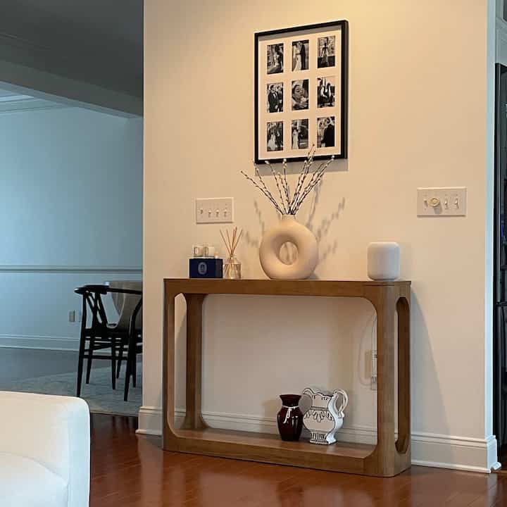 Minimal Japandi styled interior with white walls and wood tone console table blending natural aesthetics