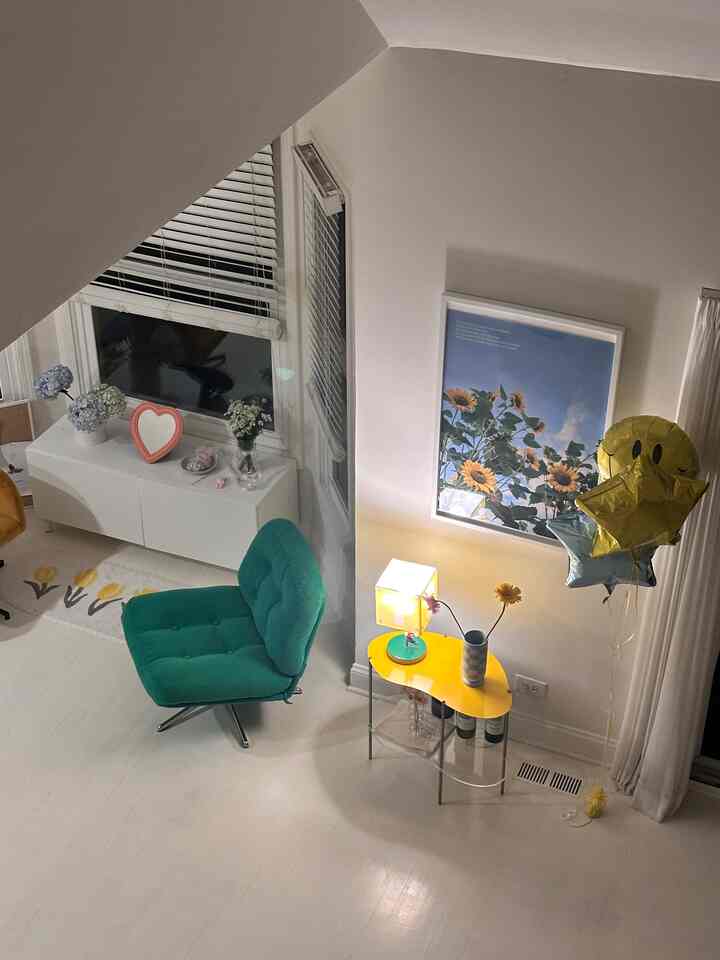 Bright living room with white walls and floor as background, featuring a green velvet armchair and yellow side table accents