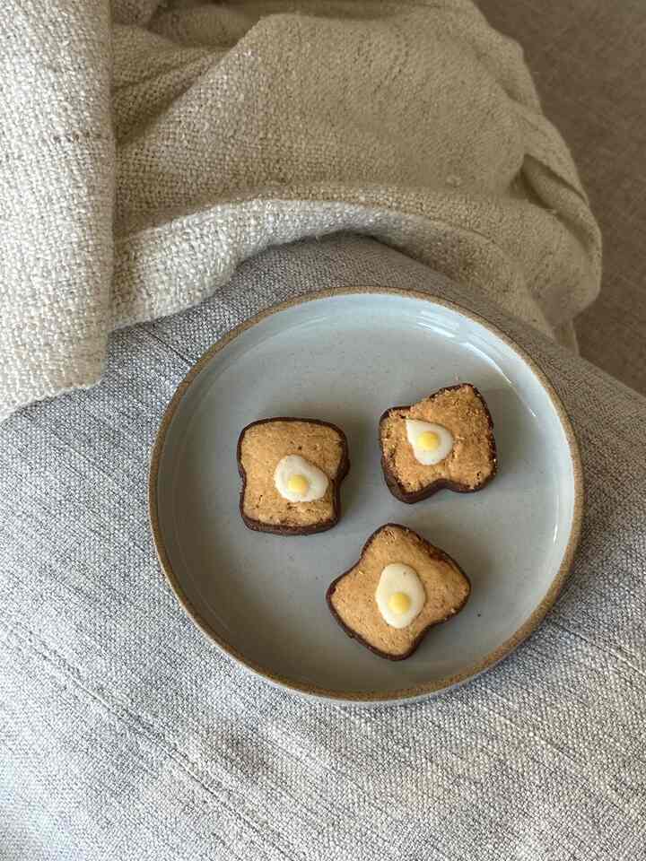 A cozy setting featuring a gray plate with small cookies on a beige-toned fabric surface