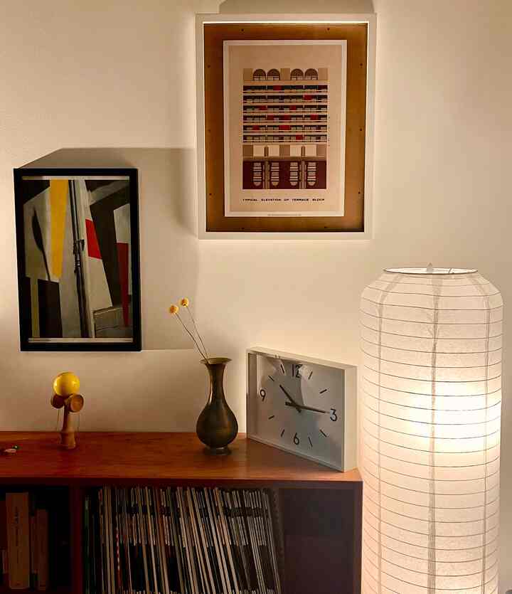 A wood-toned and ivory living room featuring a mid-century modern low shelf with a clock and picture frames, creating a cozy atmosphere