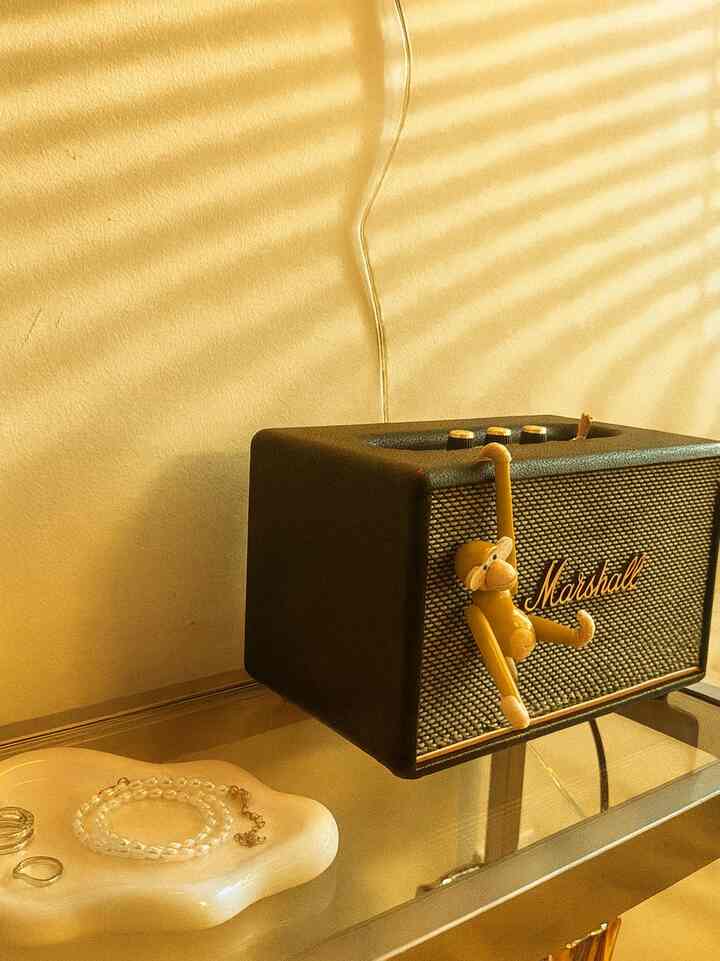 Golden-toned space featuring a Marshall speaker and a monkey figurine creating a cozy atmosphere