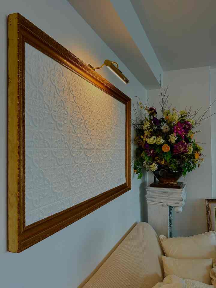 Living room with warm tones featuring a gold-framed wall art and beige sofa