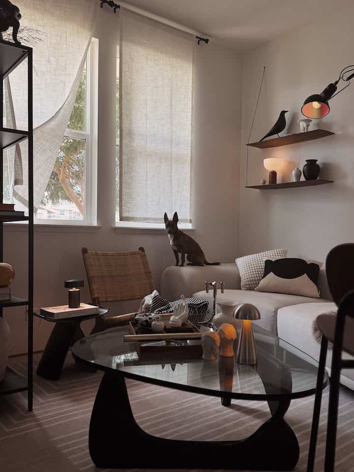 Light beige and black toned living room featuring Noguchi coffee table and sofa creating a modern natural interior