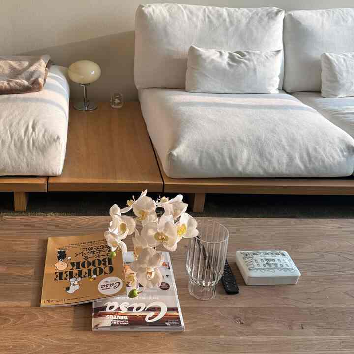 Wood tone and white living room featuring a spacious sofa and coffee table in a cozy Japandi style space