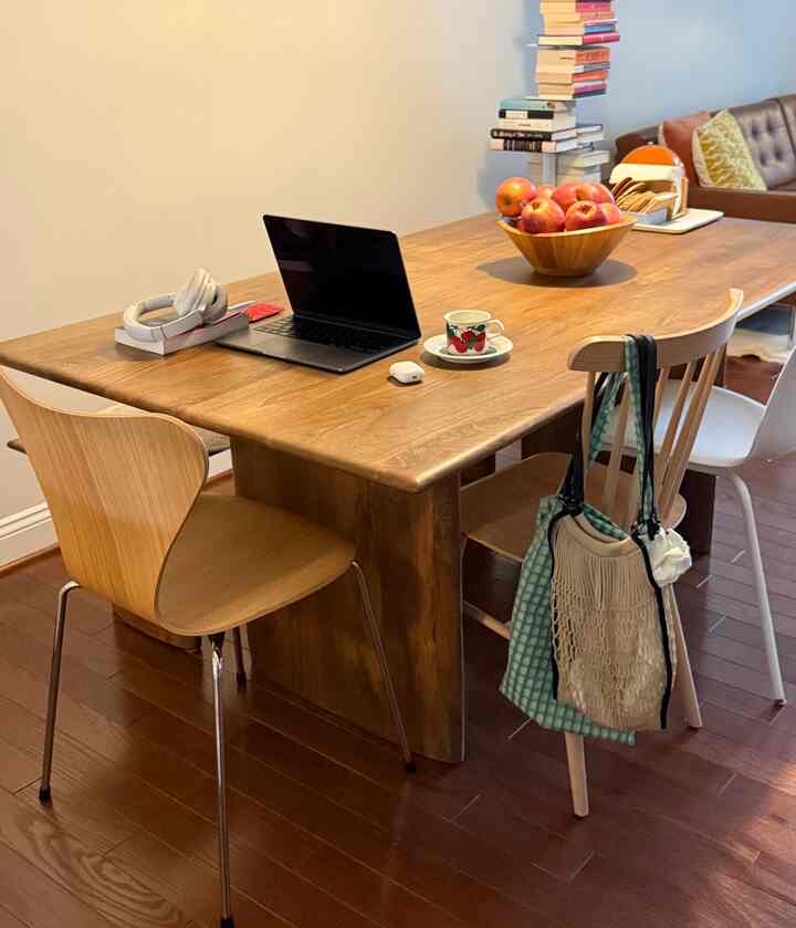 Warm wood tones in a natural dining room featuring a laptop, coffee cup, and cozy home cafe with remote work setup