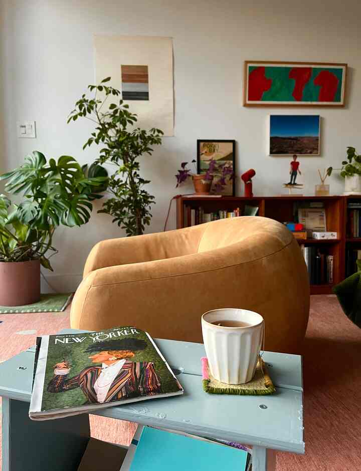 Cozy mid-century modern living room featuring a caramel brown leather swivel chair and multiple plants